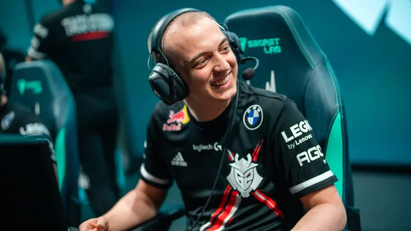 Caps smiling while sitting on stage in G2 Esports jersey with headset, during a League of Legends match