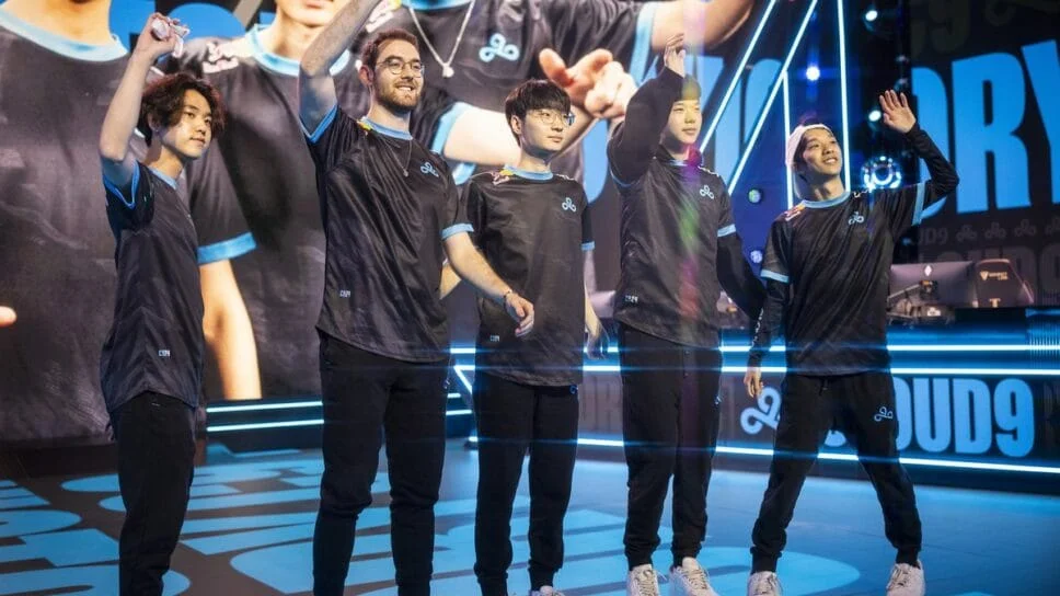 Cloud9 League of Legends team waving to the crowd on stage after a match, wearing black and dark blue jerseys
